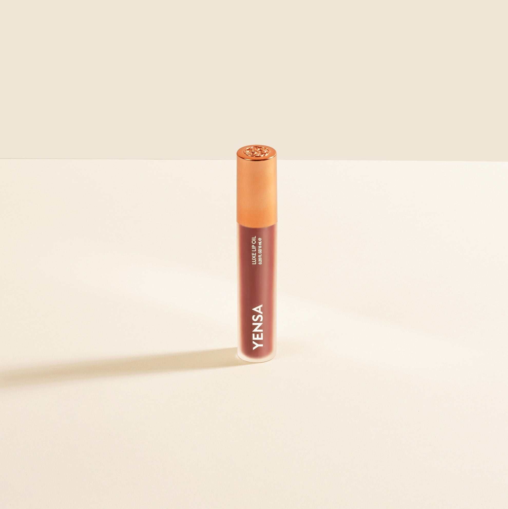 Luxe Lip Nourishing Oil in a slim peach-toned tube with a glossy finish and white vertical branding