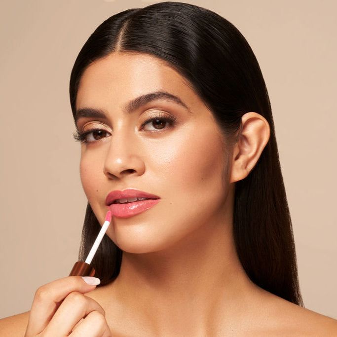 Luxe Lip Nourishing Oil in a rosy pink tint, applied with a slim doe-foot wand for a glossy lip finish