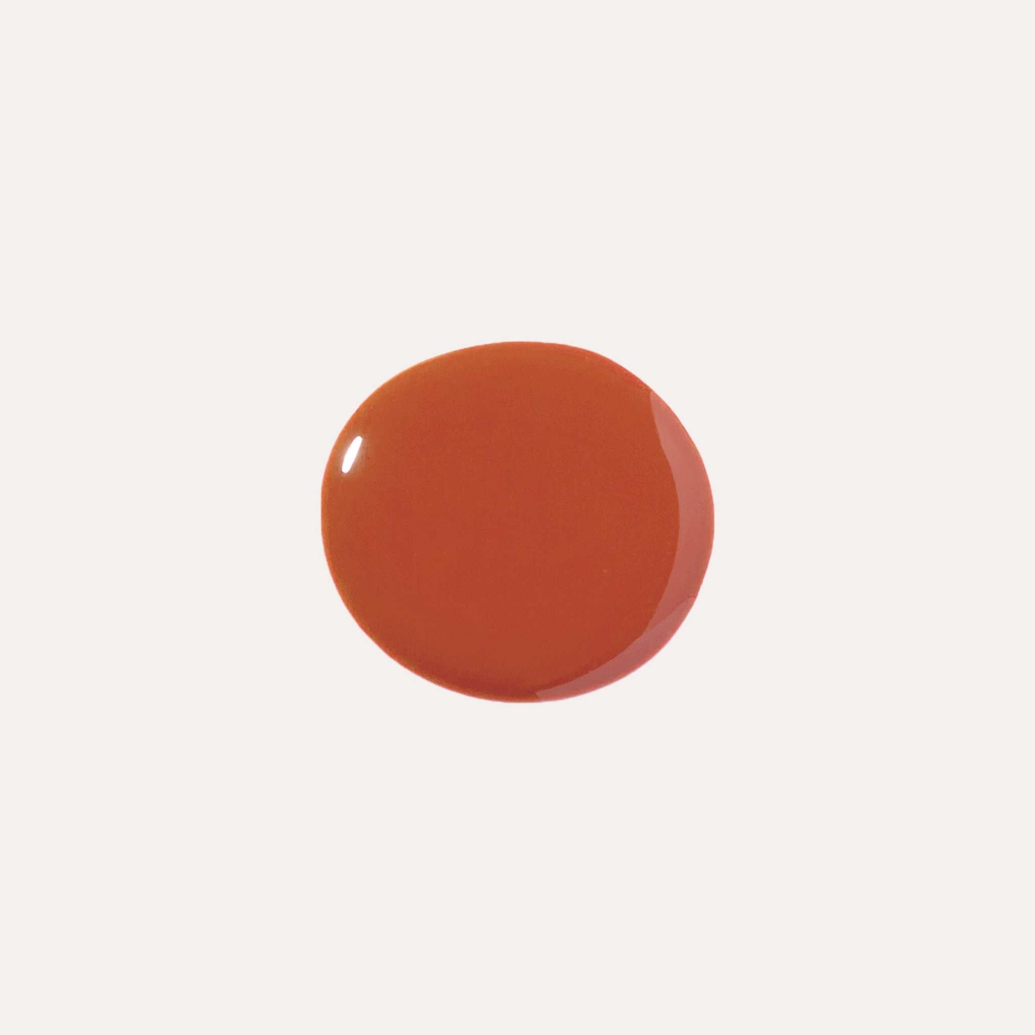 Luxe Lip Nourishing Oil is a glossy terracotta-red swatch with smooth, opaque colour and a rounded shape