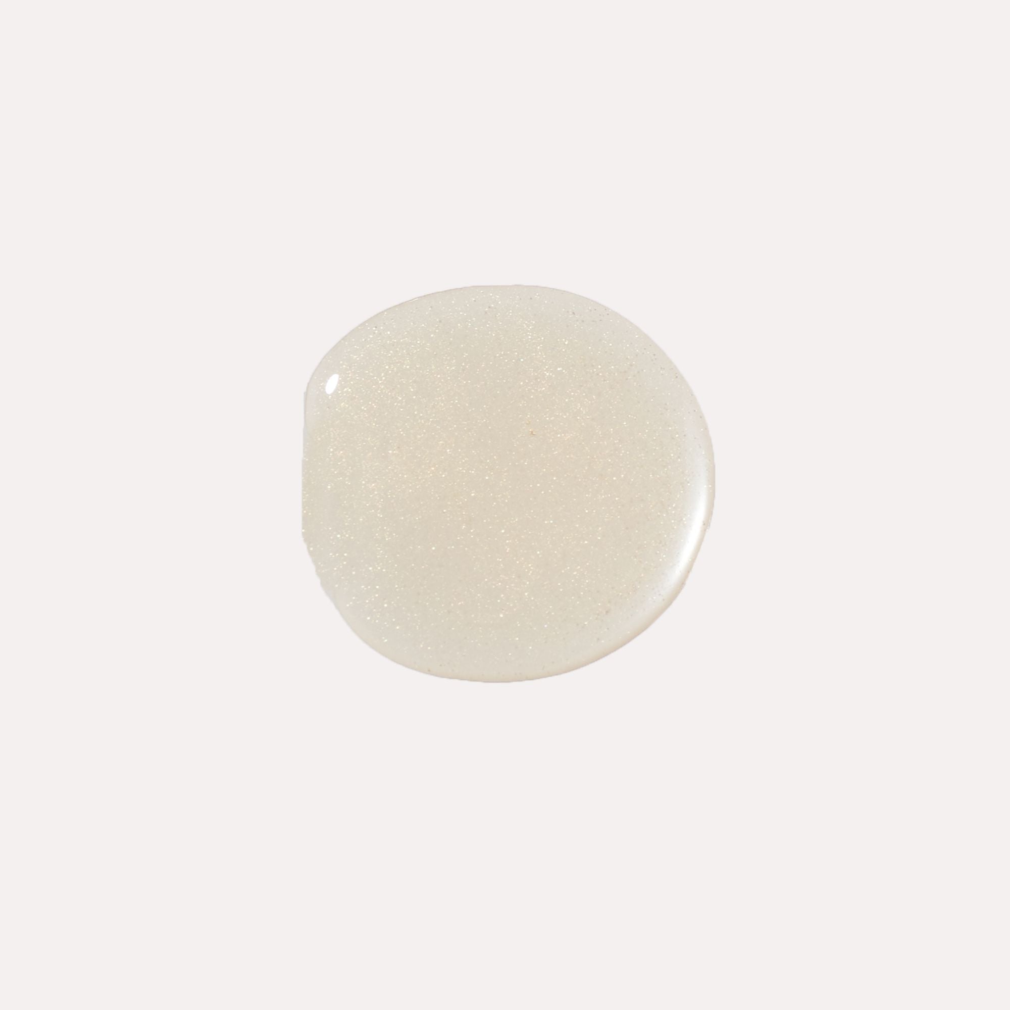 Luxe Lip Nourishing Oil in a translucent pearlescent shade, shown as a smooth, glossy swatch with fine shimmer