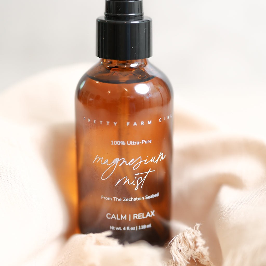 Magnesium Mist Body Spray in an amber glass bottle with black spray pump and white lettering
