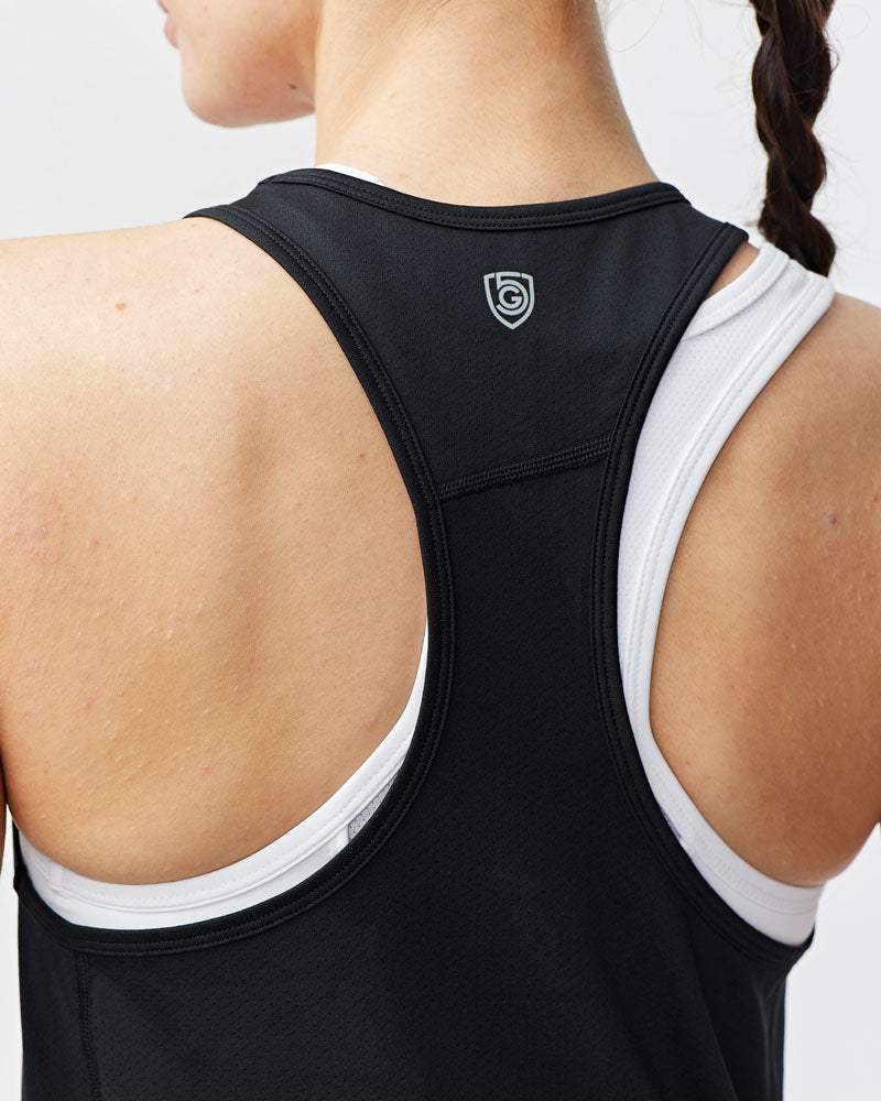 Mesh It To Me Tank in black mesh with a racerback cut and small emblem, layered over a white sports bra