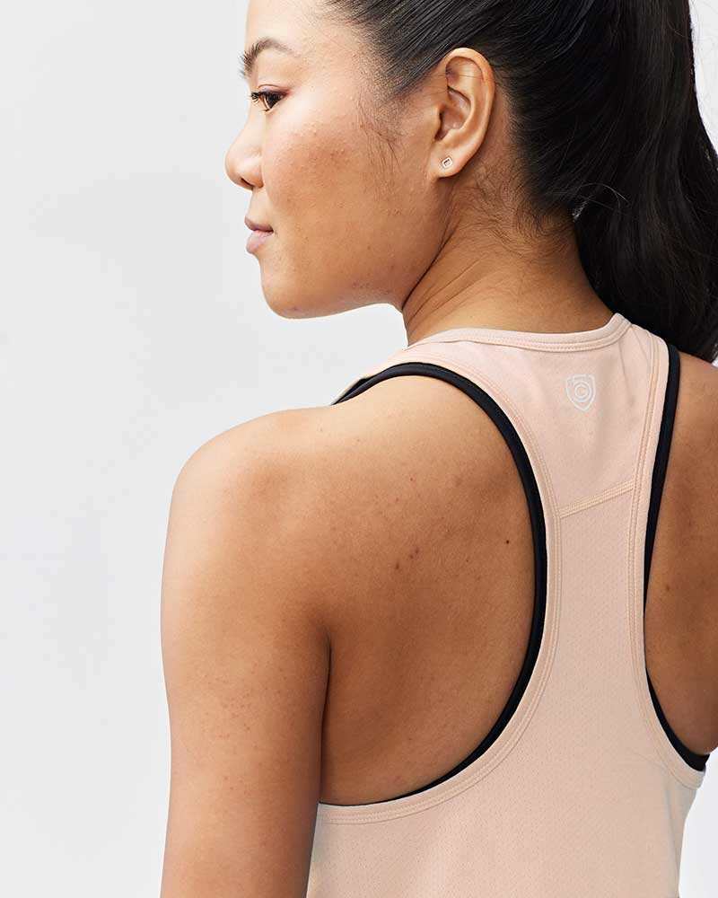 Mesh It To Me Tank in pale blush mesh with black-trimmed racerback straps and a small logo at the upper back
