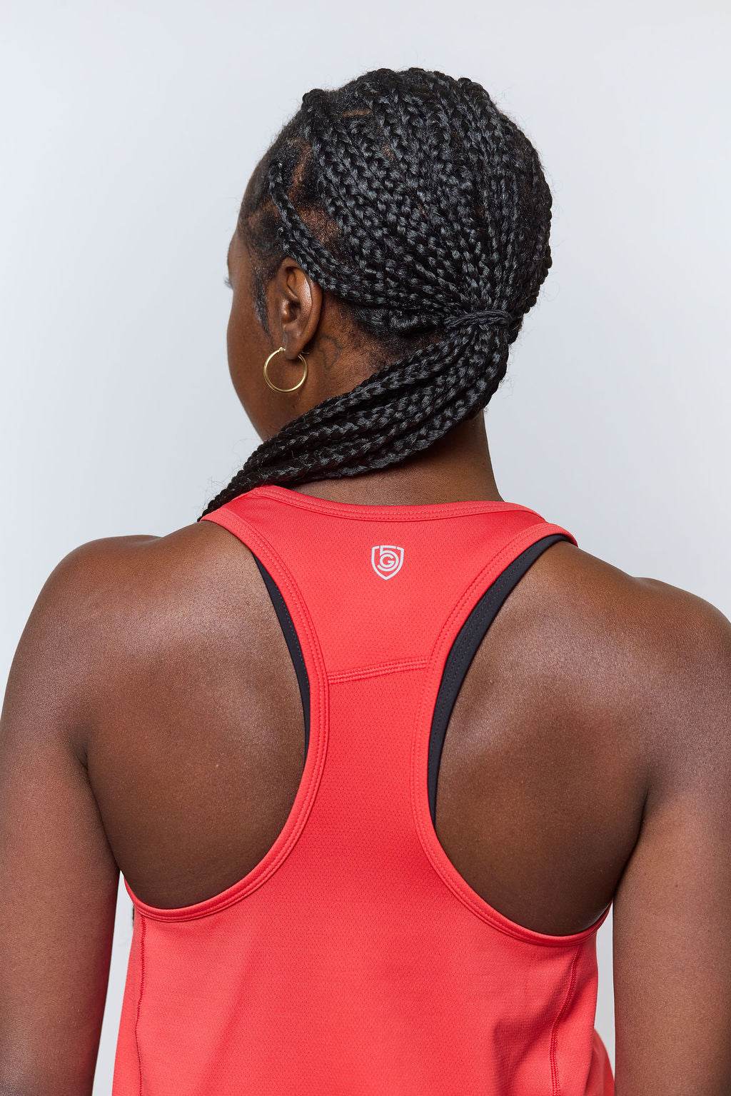 Mesh It To Me Tank in coral red with black-trimmed racerback straps and a small white emblem at the back