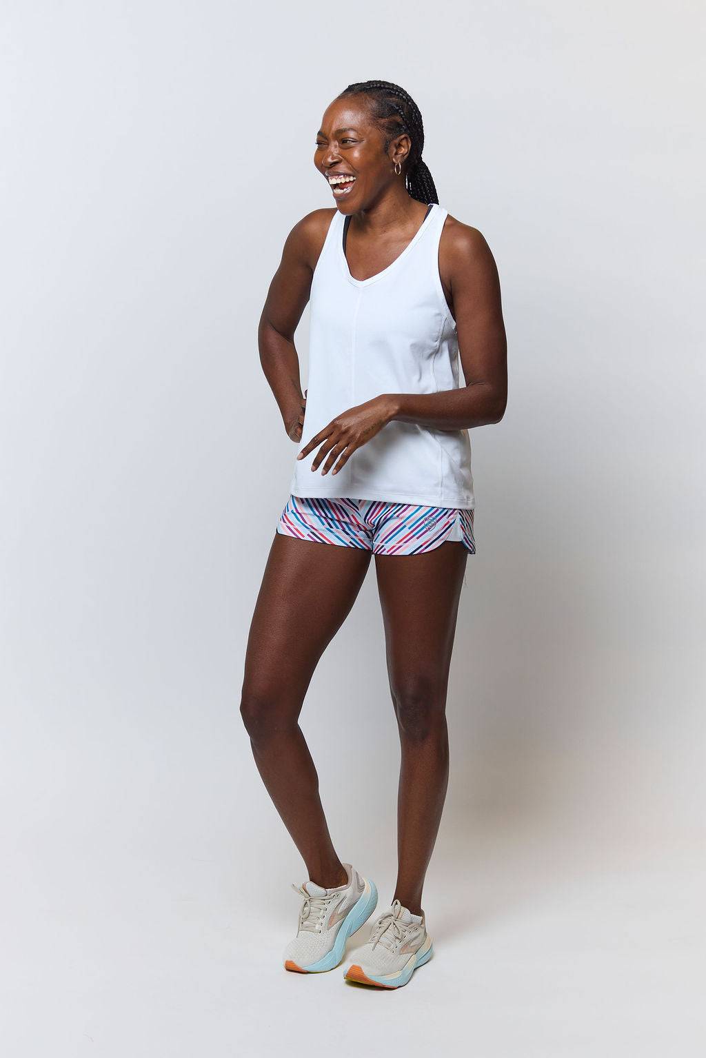 Mesh It To Me Tank in white with a sleeveless V-neck silhouette, worn with brightly striped shorts