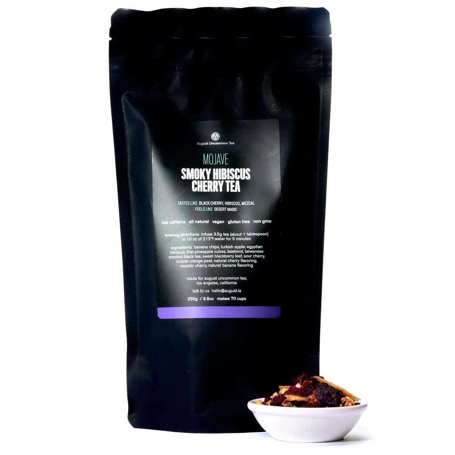 Mojave - Smoky Hibiscus Cherry Tea in a black resealable pouch, with a bowl of colorful dried tea ingredients.