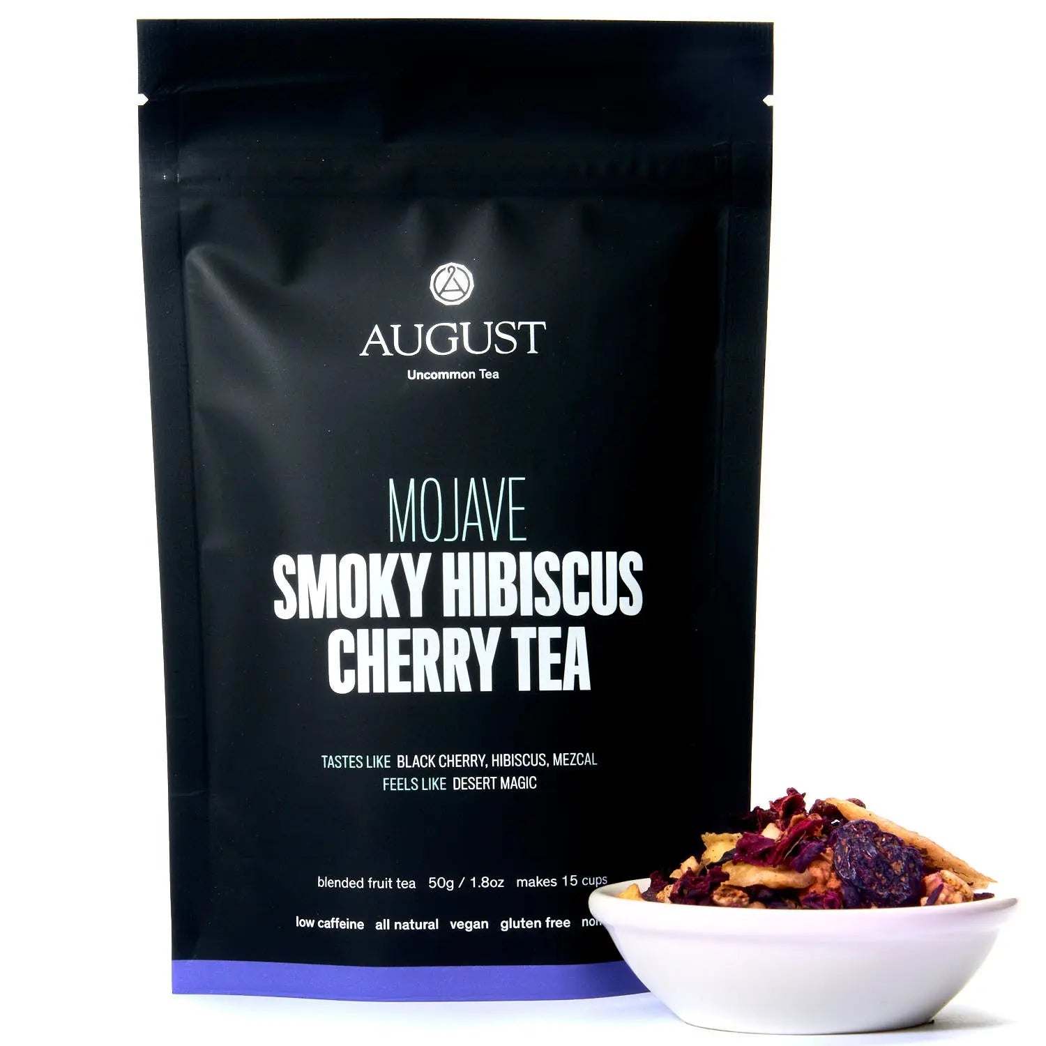 Mojave - Smoky Hibiscus Cherry Tea in a black pouch beside a bowl of colorful loose-leaf tea with hibiscus petals and fruit