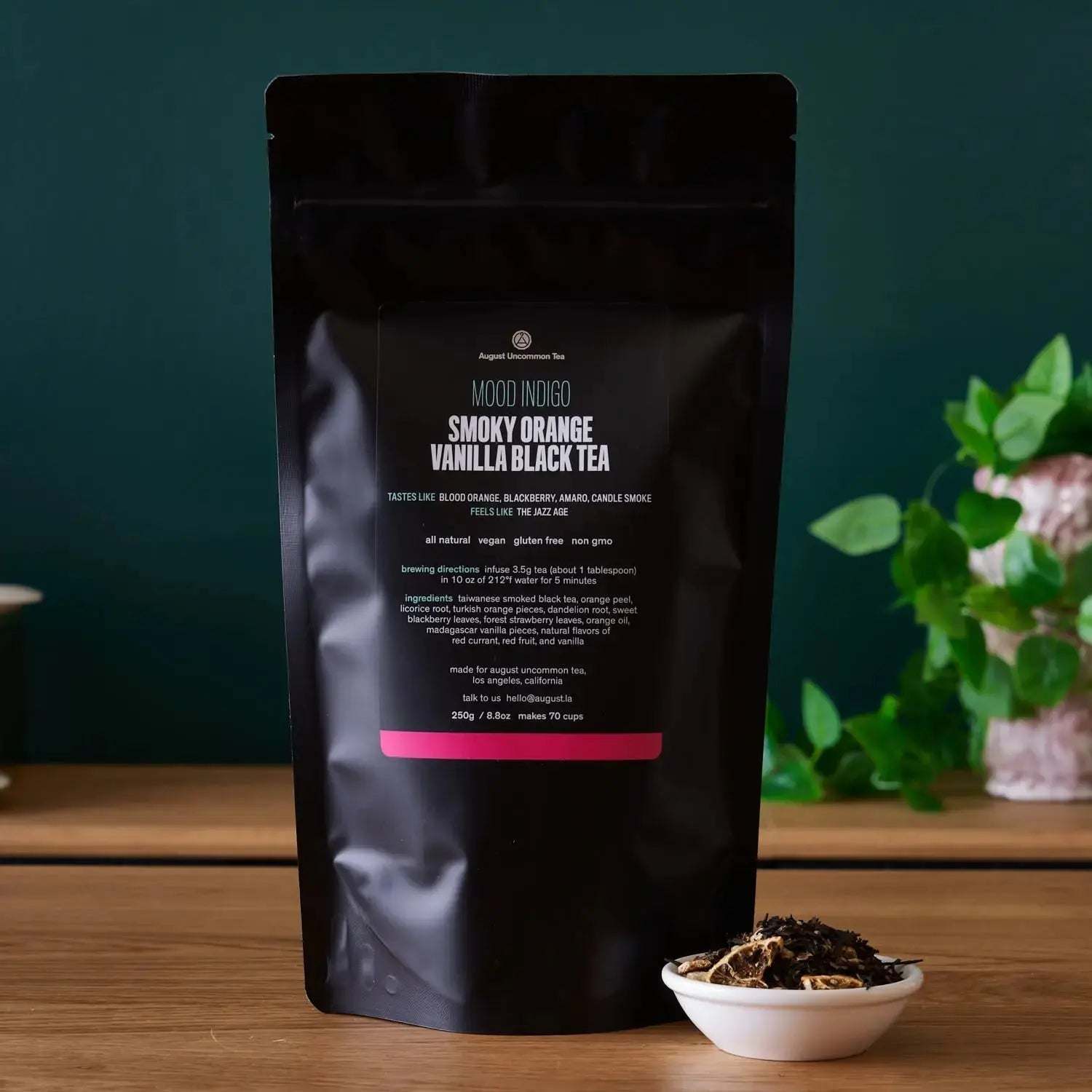 Mood Indigo - BLACK TEA in a matte black pouch, labelled smoky orange vanilla black tea, with loose tea bowl beside it