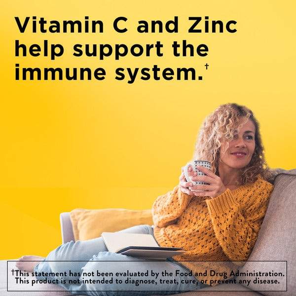 Nature Made Stress B-Complex orange bottle with white cap alongside woman in orange sweater holding a mug with vitamin C zinc text