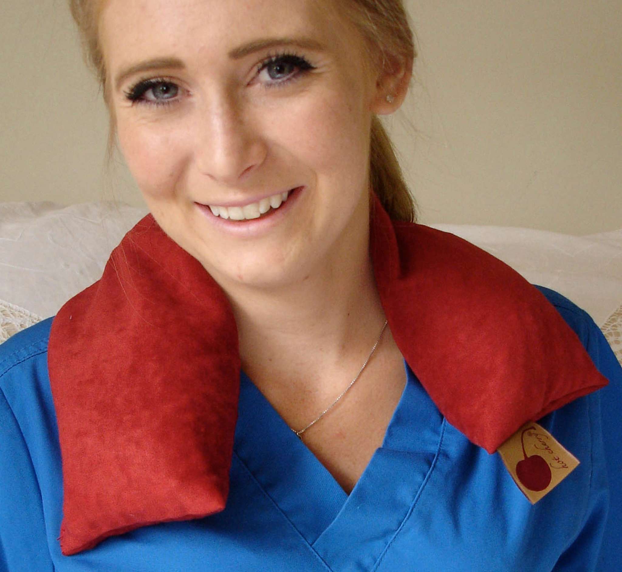 Neck Wrap in plush red suede-like fabric drapes over the shoulders, with two padded ends and a gift tag