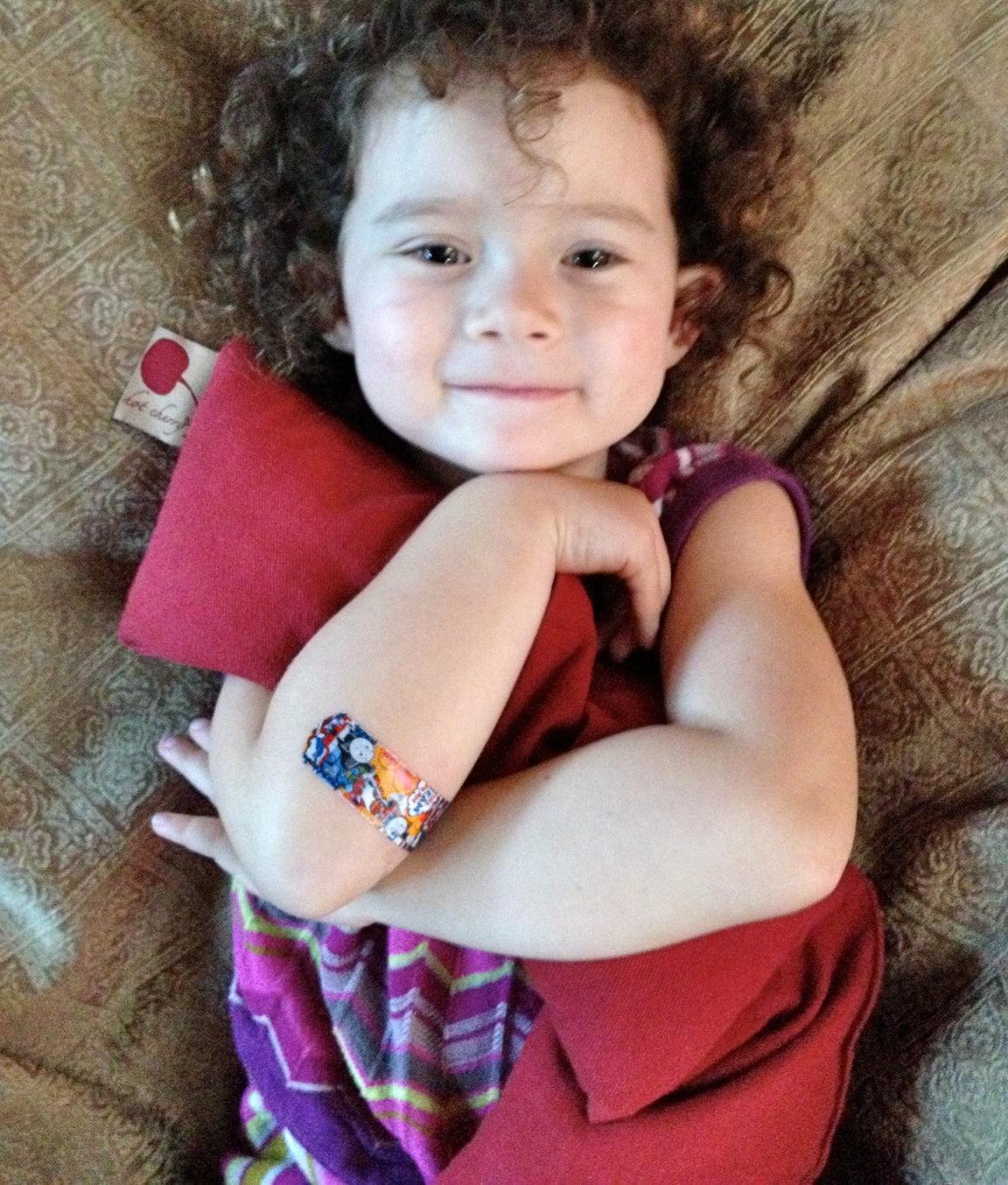 Neck Wrap in solid red fabric, a soft elongated pillow held across a child's shoulders and chest