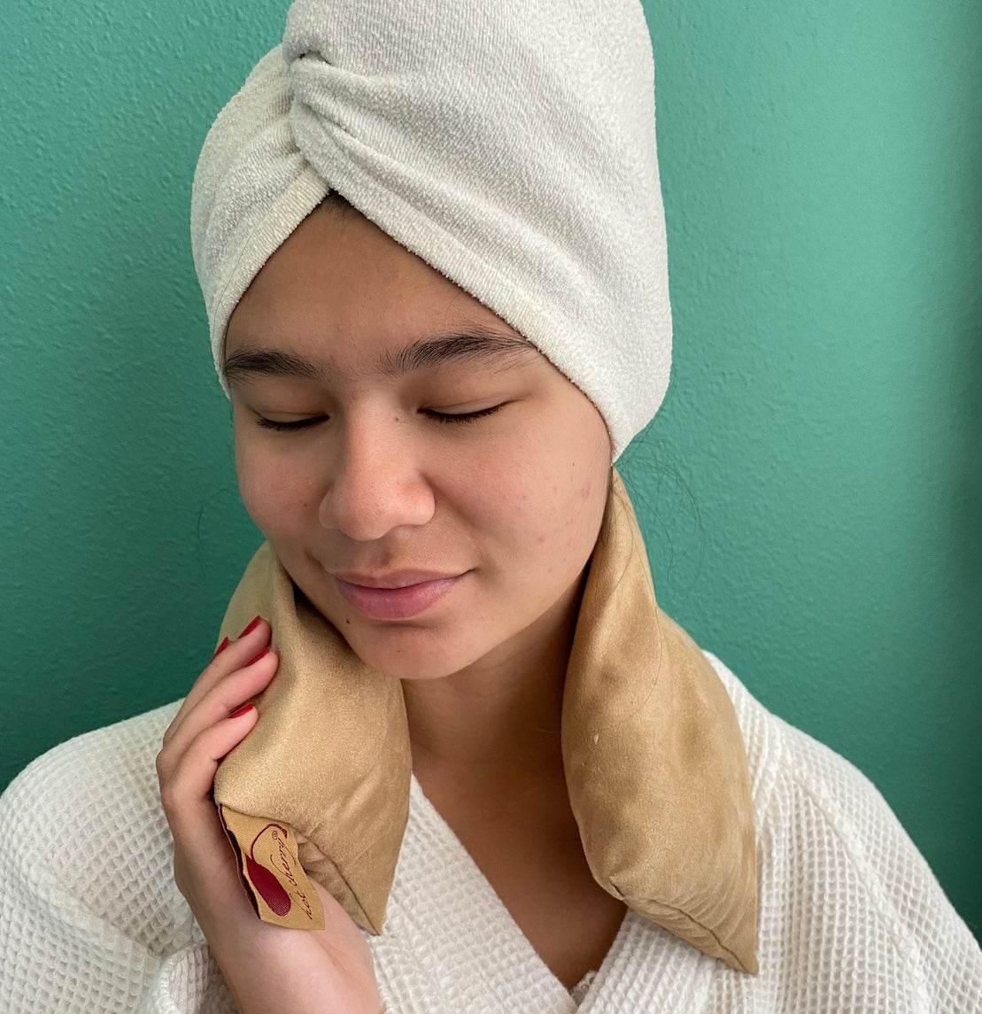 Neck Wrap in tan plush suede fabric, draped around the neck with a gift tag attached