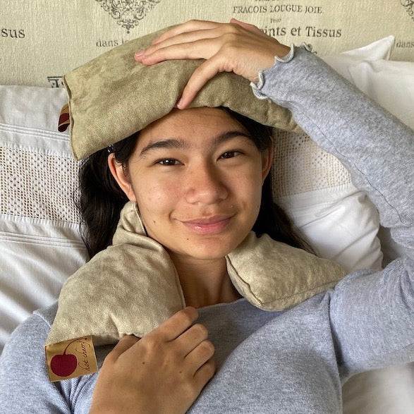 Neck Wrap in tan plush ultra-suede, draped around the shoulders with a matching padded section resting across the forehead
