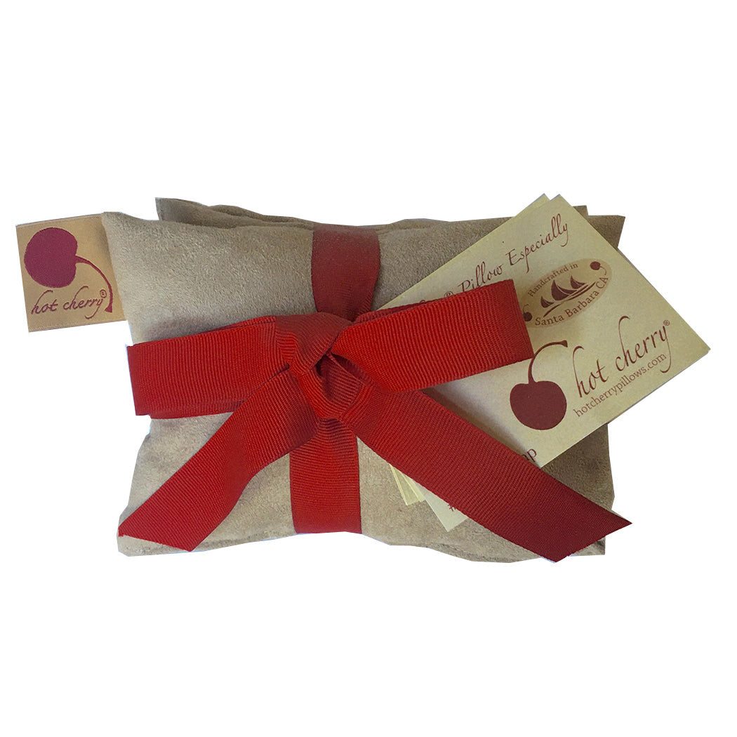 Neck Wrap in plush tan ultra-suede, bundled with a wide red ribbon and Hot Cherry gift tags