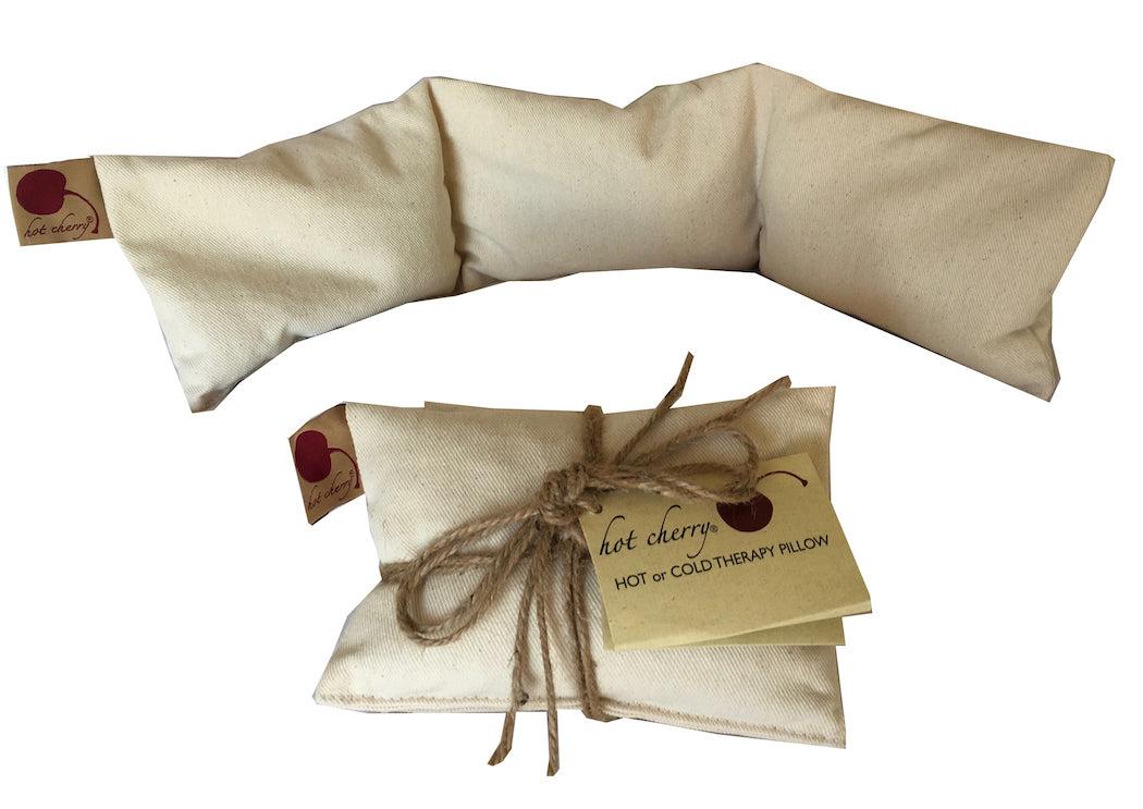 Neck Wrap pillow in unbleached natural cotton denim, with a segmented shape and twine-wrapped packaging