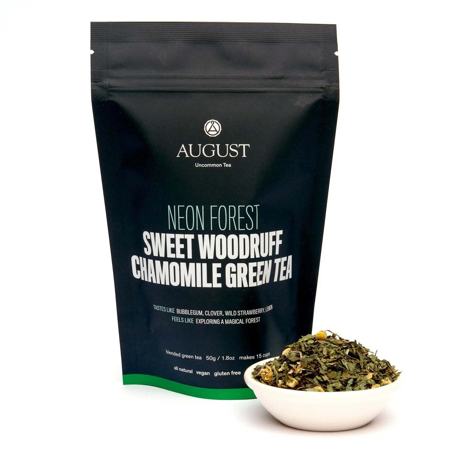 Neon Forest green tea in a black resealable pouch with white lettering, beside loose leafy tea in a bowl