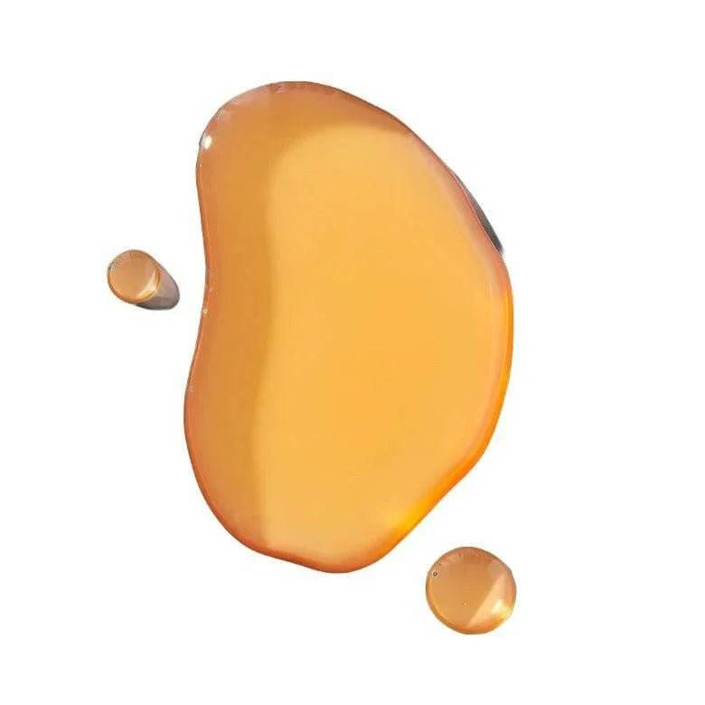No. 1 - Bois Sacré Body Oil shown as glossy amber oil with a smooth translucent texture and rounded droplets