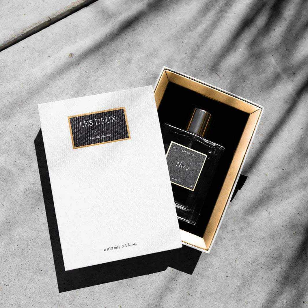 No. 2 - Peau d’Or Perfume in a black glass bottle with gold-trimmed box and white Les Deux sleeve