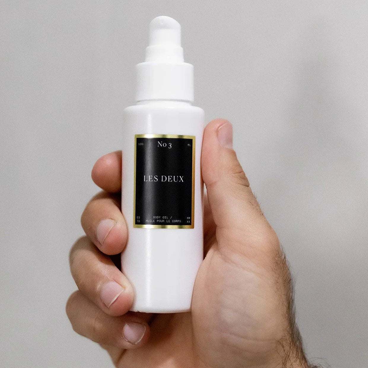 No. 3 - Brume Ardente Body Oil in a white pump bottle with a black and gold label