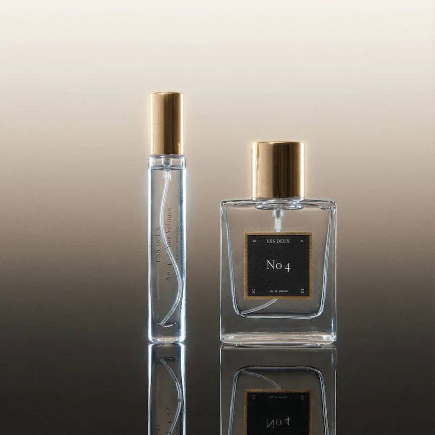No. 4 - L'Âme Velours Perfume in clear glass bottles with gold caps and black labels, including a sample vial
