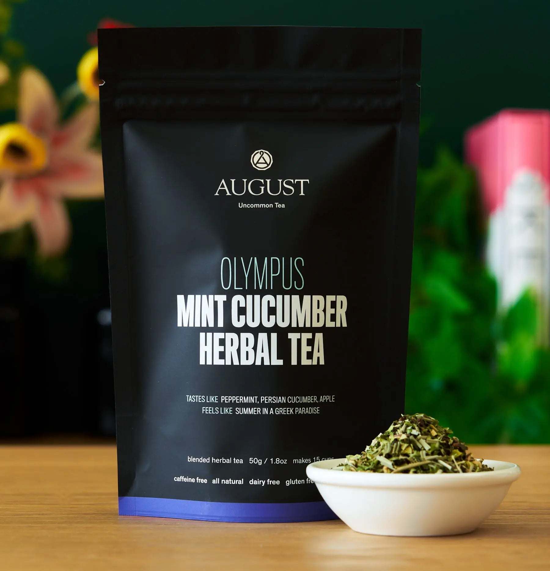 Olympus - Mint Cucumber Herbal Tea in a black resealable pouch with a bowl of loose herbal tea beside it