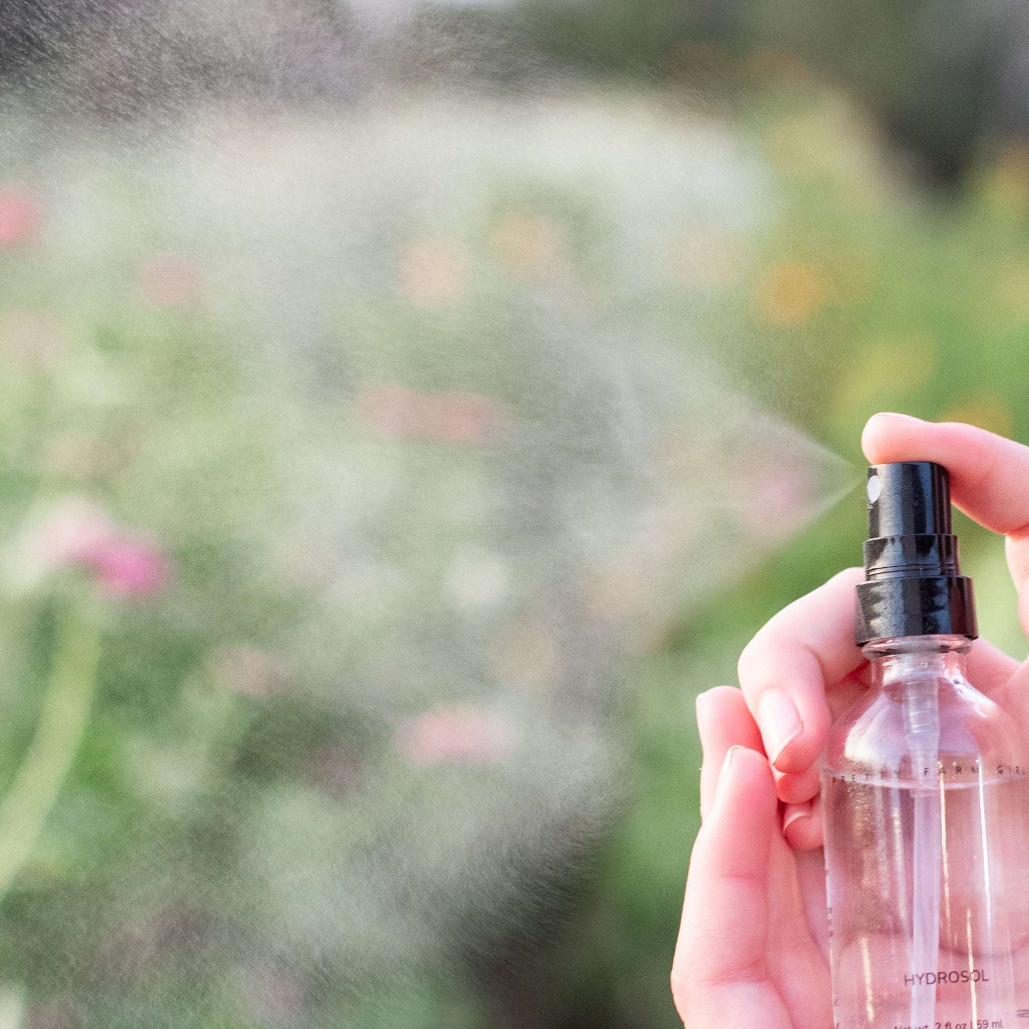 Organic Turmeric Facial Toner in a clear glass spray bottle with black pump releasing a fine mist
