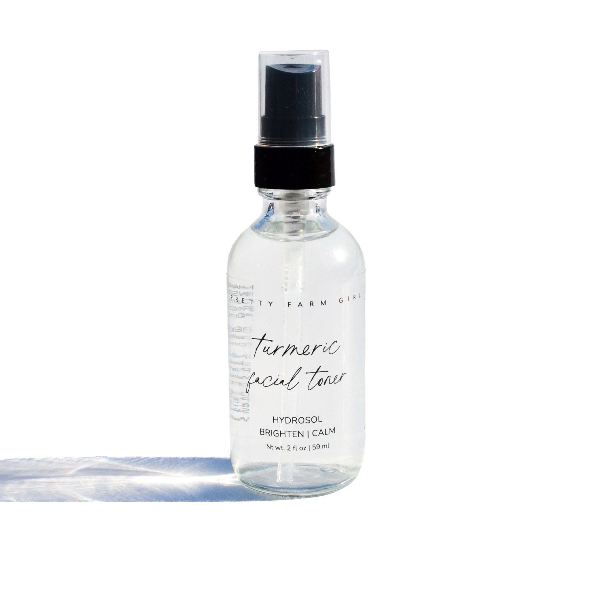 Organic Turmeric Facial Toner in a clear glass spray bottle with black pump and handwritten label