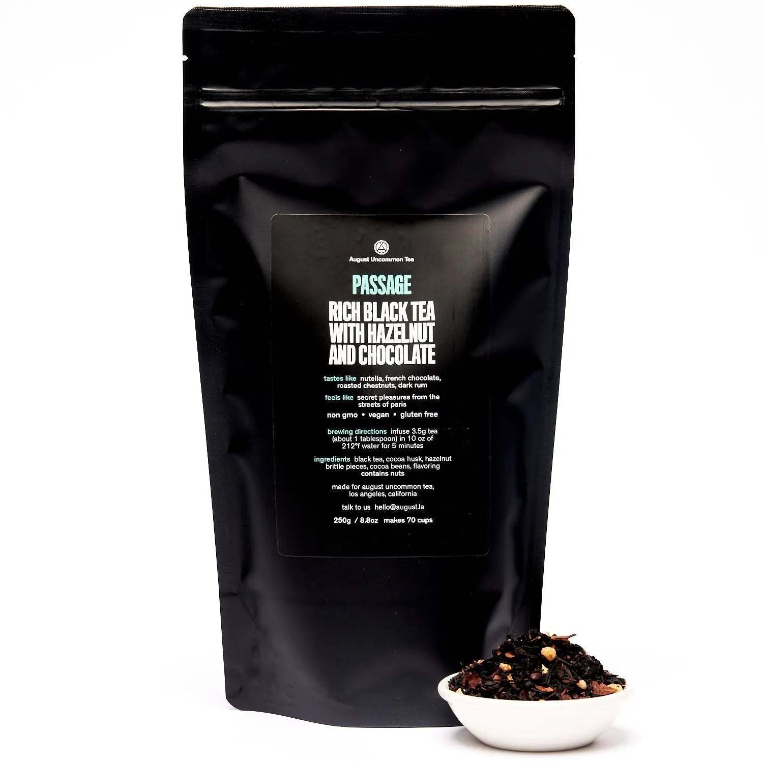 Passage - Hazelnut Chocolate Black Tea in a glossy black resealable pouch beside loose dark tea with visible nut pieces