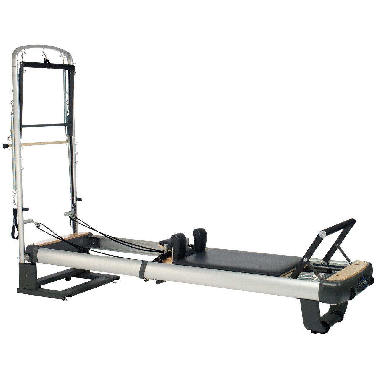 Peak PilateSystem® Deluxe Bundle with black padded reformer carriage, silver metal frame, wooden accents, and tower attachments