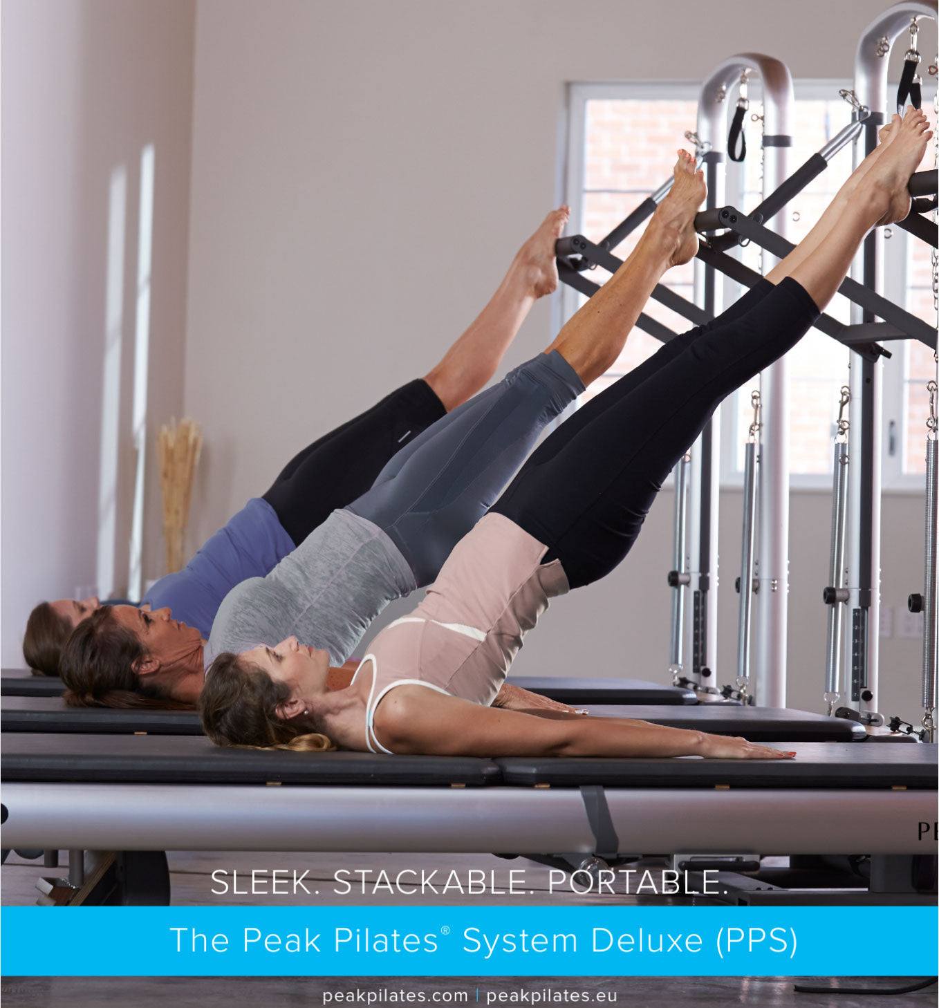 Pilates reformer machines with black frames and padded platforms being used by three women in workout attire, showcasing the Peak PilateSystem® Deluxe Bundle in action.