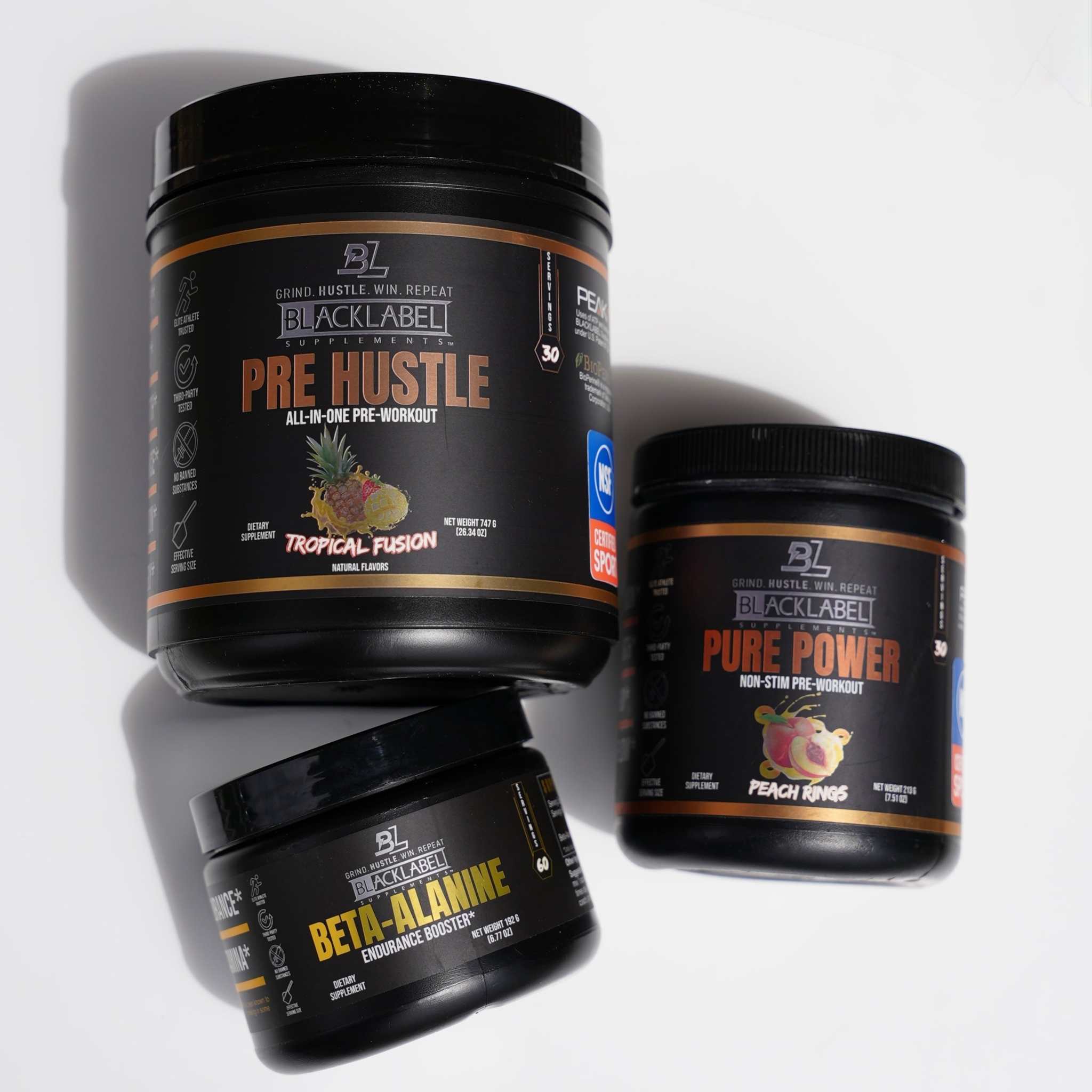 PERFORMANCE STACK of three black supplement tubs, including Pre Hustle, Pure Power and Beta-Alanine with bold labels