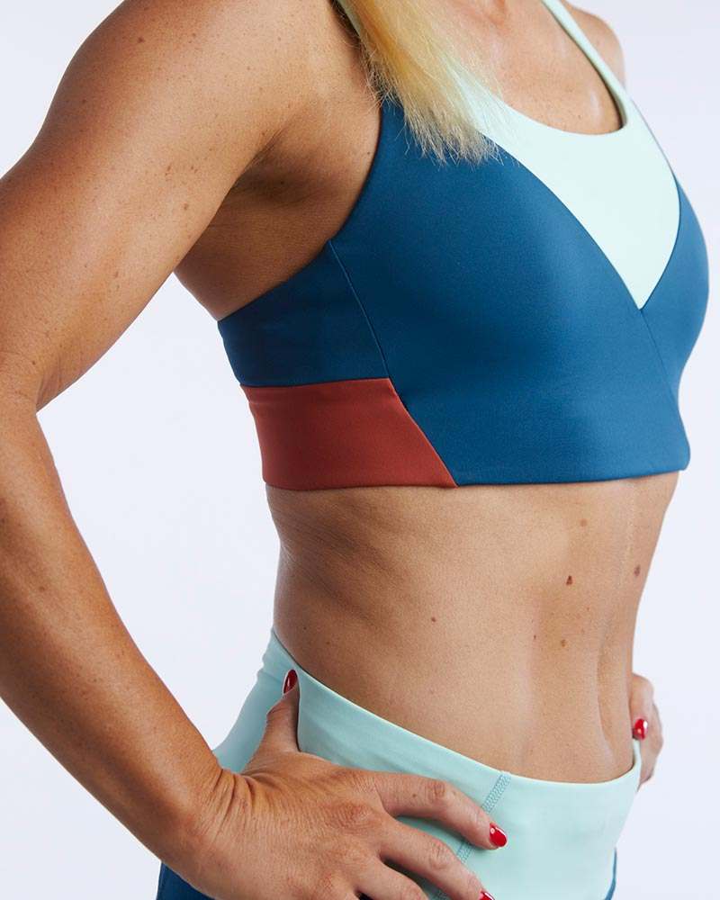 Pionxr Bra Top with a blue and rust color-blocked body, pale aqua neckline insert and wide lower band