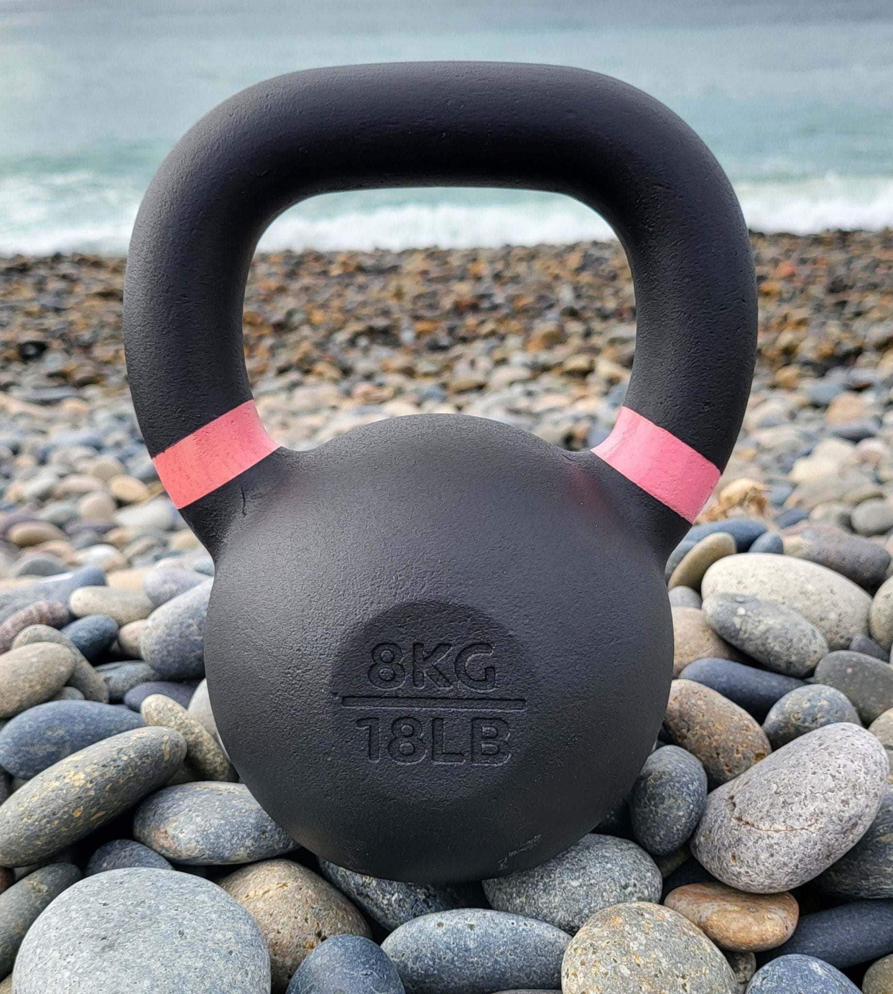 Powder coated kettlebell with textured grip and color-coded handle