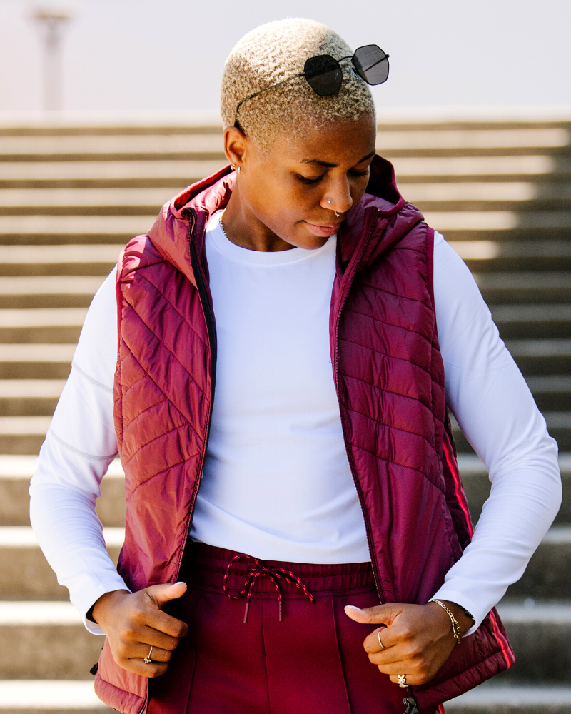 Powerstripe Eco-Friendly Down Hooded Vest in burgundy quilted fabric with a hood and sleeveless design, worn open