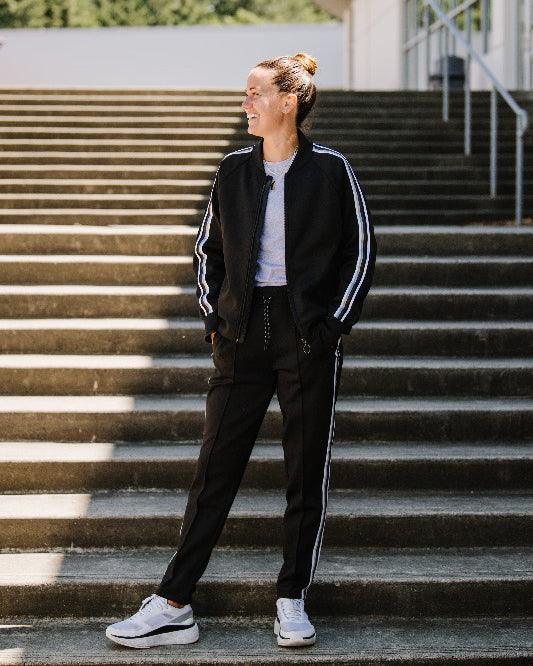 Powerstripe LS Track Jacket in black with white double sleeve stripes, full-length zipper, ribbed cuffs and collar