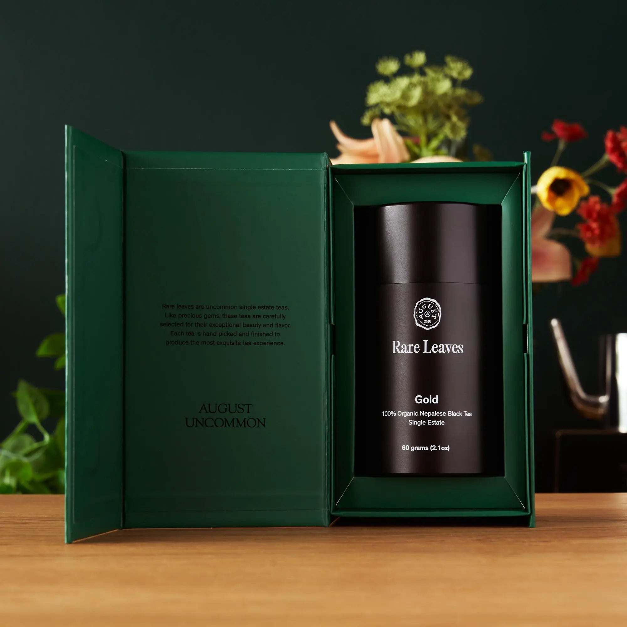 Premium Loose Leaf Tea gift set with a black cylindrical Gold Rare Leaves tin in a dark green presentation box