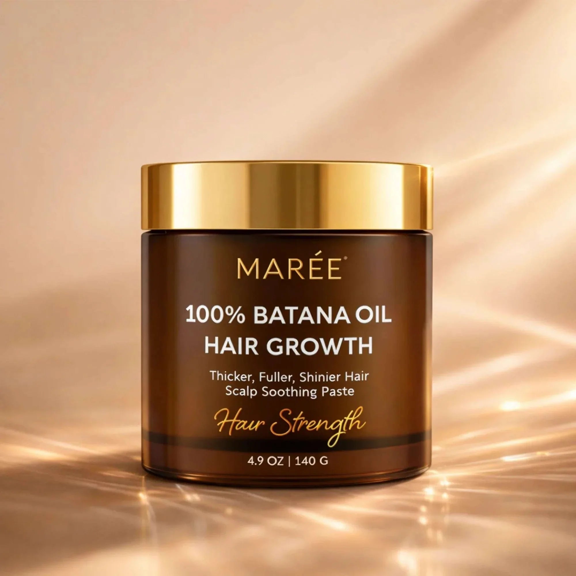 Pure Batana Hair Growth Paste in a dark amber jar with a shiny gold lid and gold and white lettering