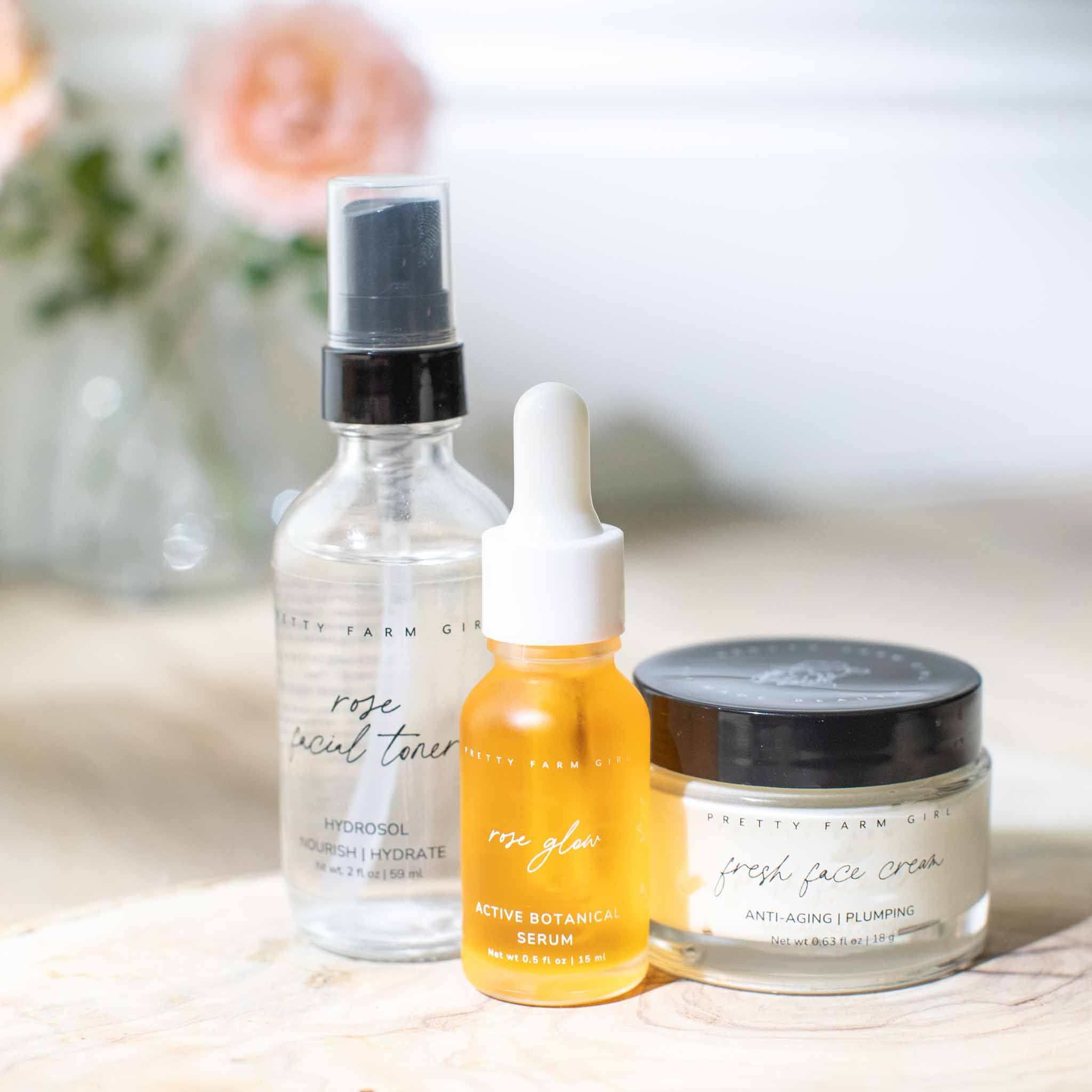 Radiance Glow Kit with clear glass rose facial toner spray, amber dropper serum, and cream jar