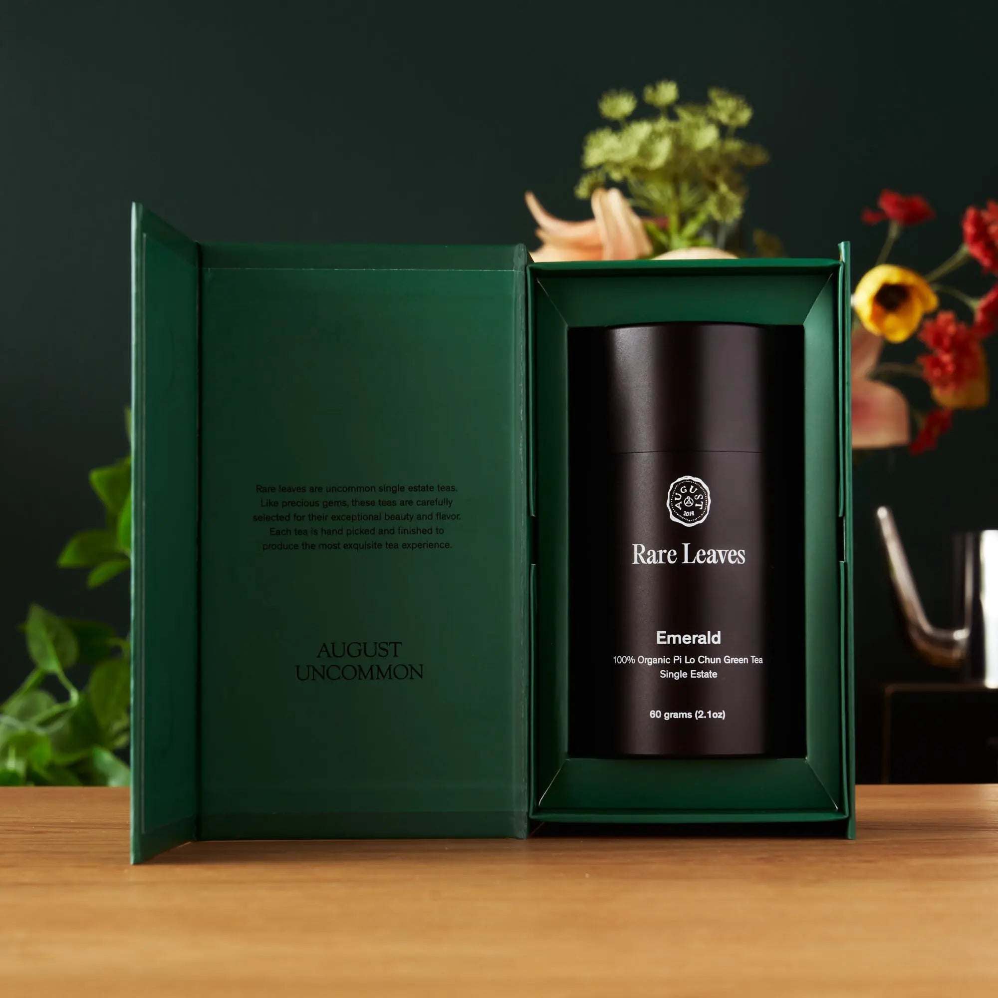 Rare Leaves Emerald - Pi Lo Chun Green Tea in a black cylindrical tin with a dark green gift box