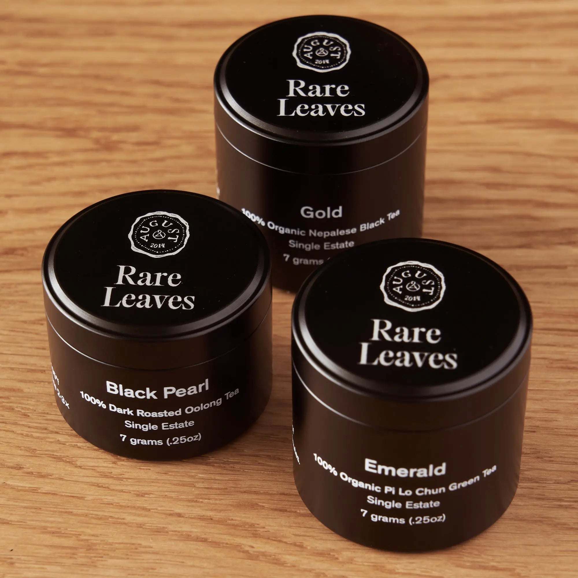 Rare Leaves Single Origin Tea Mini Tin Sample featuring three black aluminum tins labeled Gold, Black Pearl, and Emerald teas