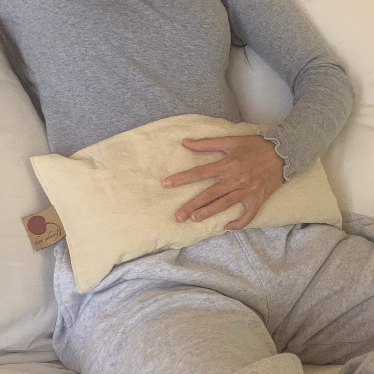 Rectangle/Cervical Pillow in cream-colored natural fabric, rectangular with a soft, subtly textured surface and tag