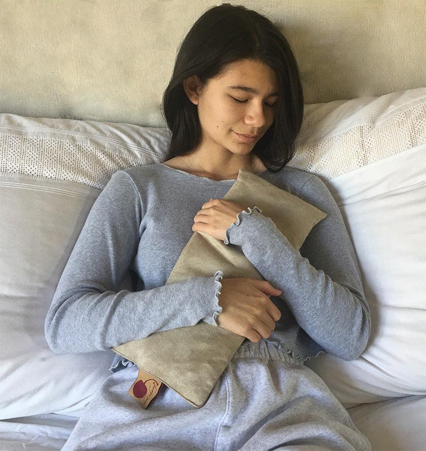 Rectangle/Cervical Pillow in tan ultra-suede, a soft rectangular pillow with ruffled edges and a small fabric tag