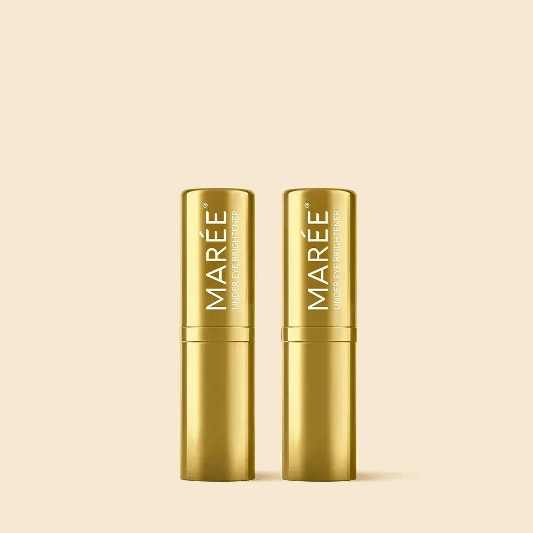 Retinol Under Eye Brightener in two metallic gold balm sticks with slim cylindrical cases and vertical MAREE branding