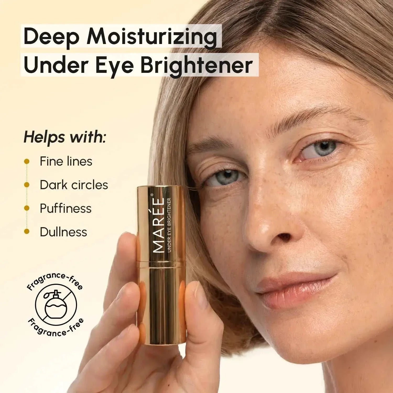 Retinol Under Eye Brightener golden metallic balm stick held beside a woman's face, with a sleek cylindrical tube