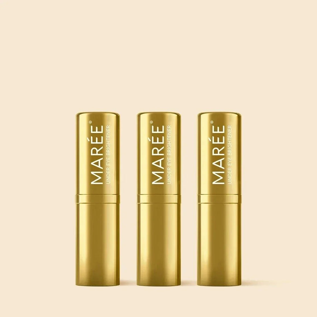 Retinol Under Eye Brightener in three shiny gold stick tubes with white vertical Maree branding