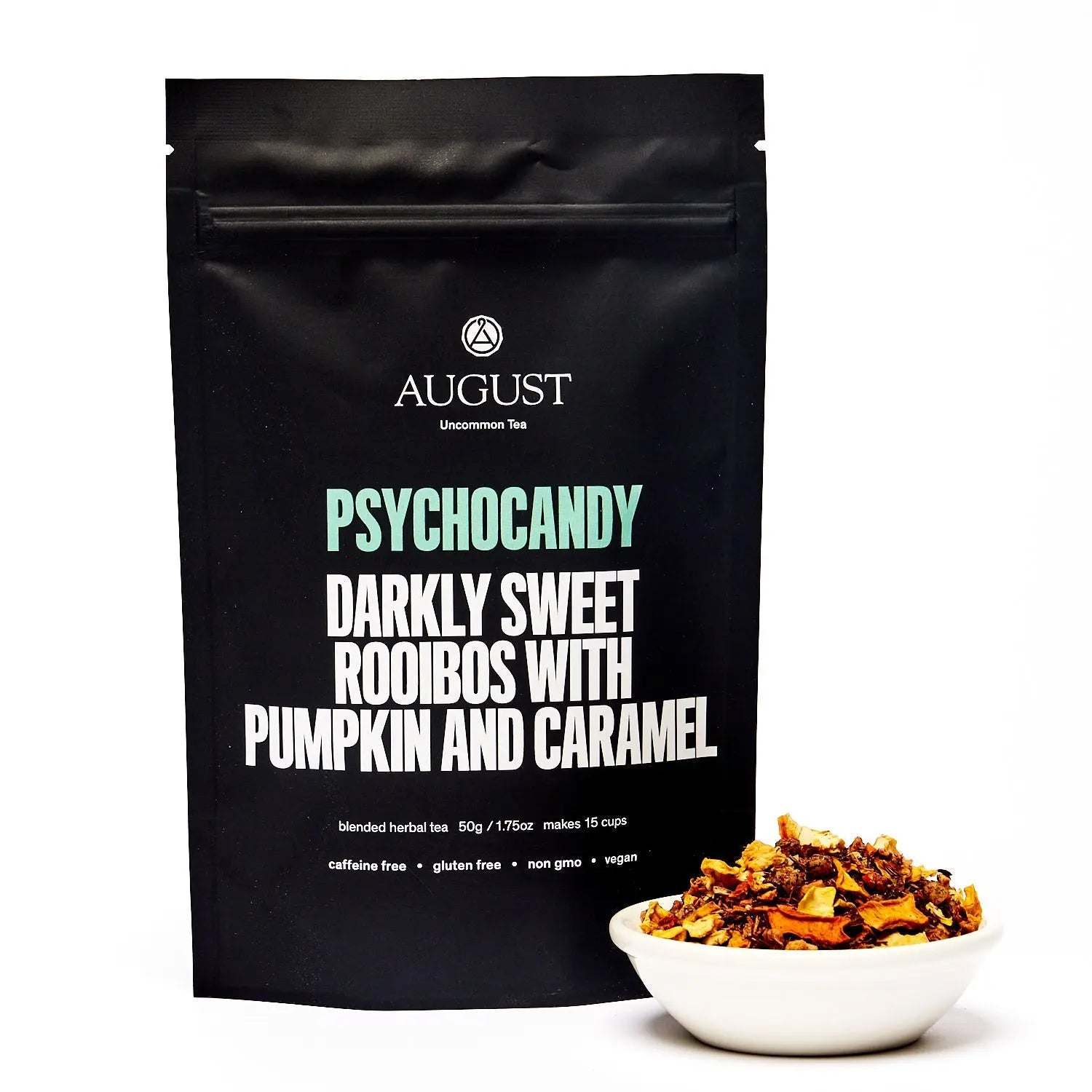 Roasted Pumpkin Caramel Rooibos Tea in a black August pouch, with pumpkin and caramel herbal tea pieces in a white bowl