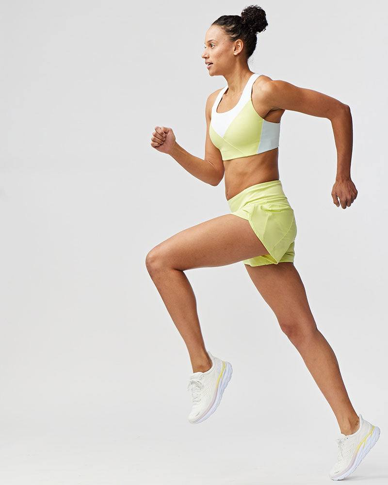 Sheva Women's High Rise Running Shorts in bright lime green, with a high-rise waistband and lightweight pleated panels