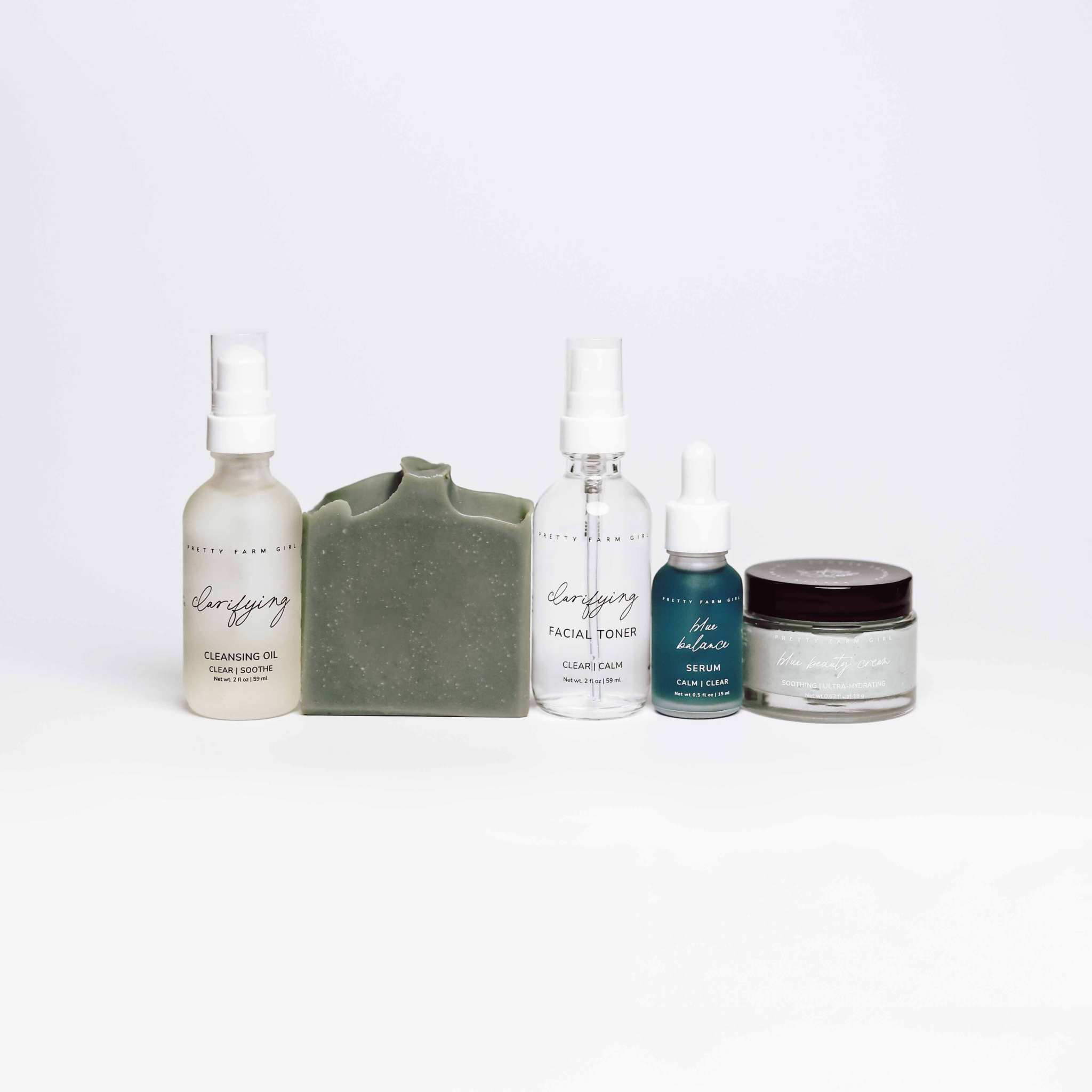Skin Redness Skincare Routine Kit with green soap bar, glass oil and toner bottles, serum dropper, and cream jar