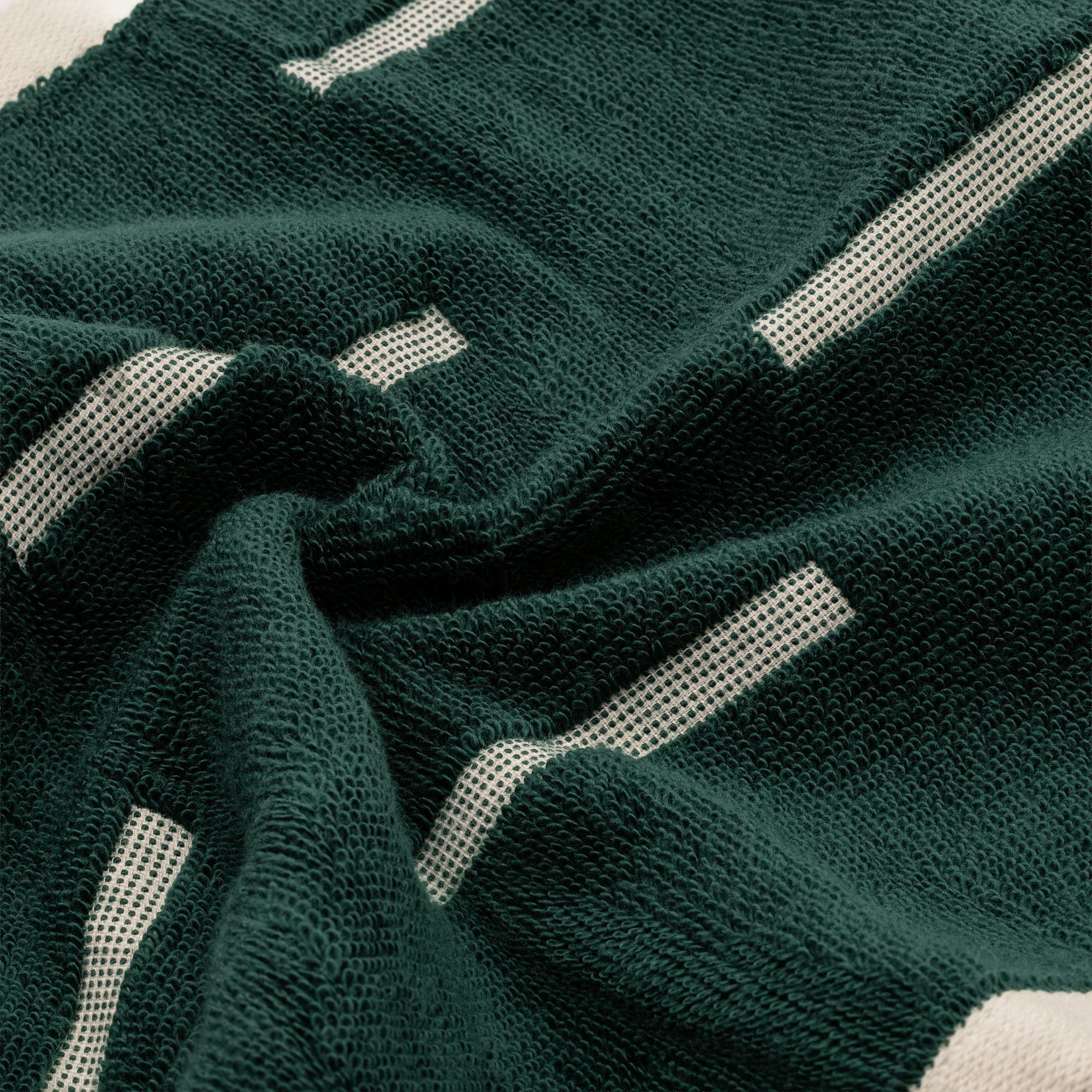 Sorrel Australian Cotton towel in deep forest green with a plush looped texture and bold cream geometric stripes