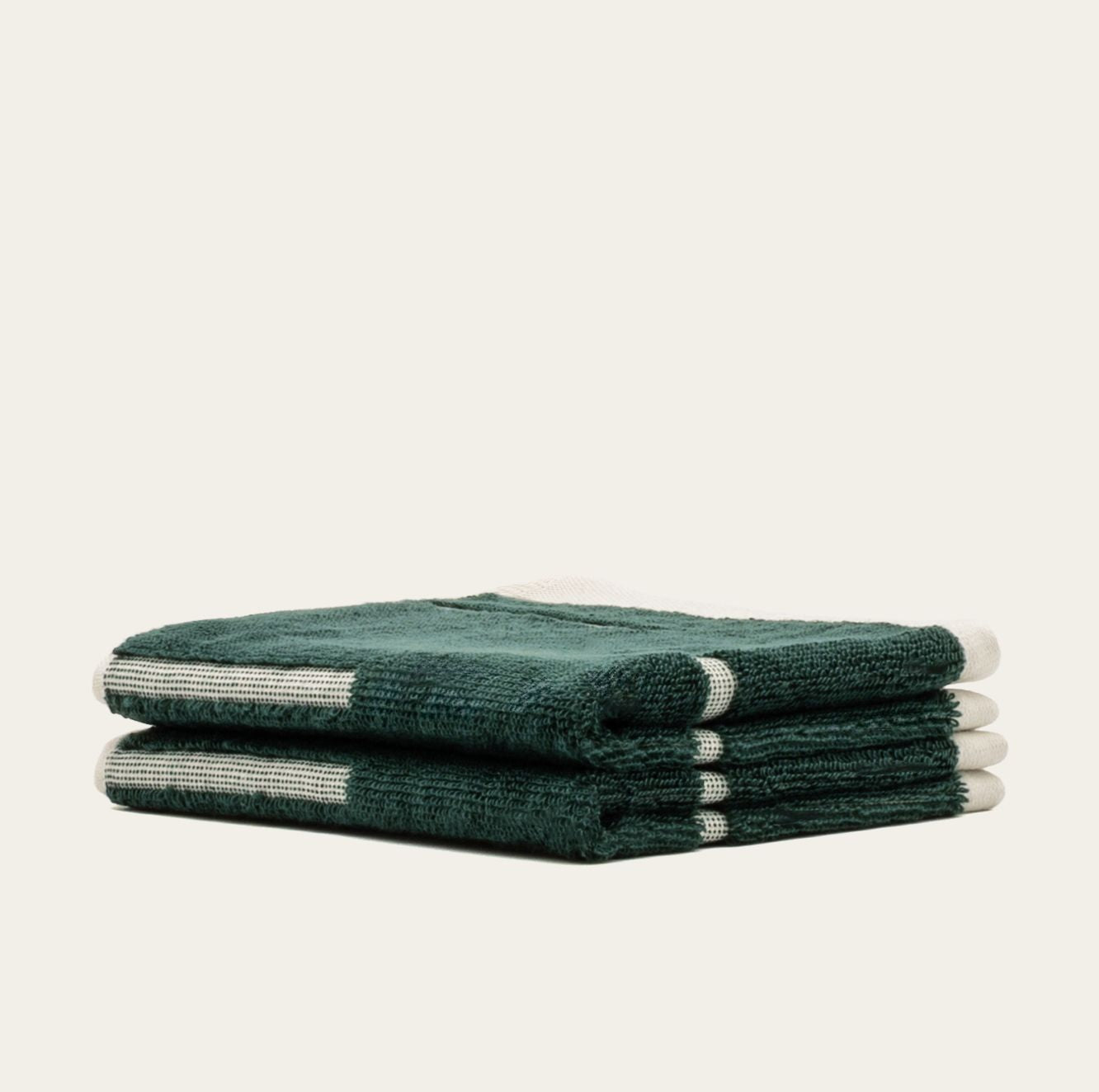 Sorrel Australian Cotton towels in deep forest green with plush terry texture and narrow cream geometric stripe accents